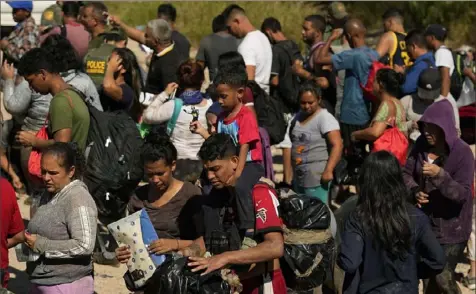  ?? Eric Gay/Associated Press ?? Migrants wait to be processed by U.S. Customs and Border Patrol after they crossed the Rio Grande in Eagle Pass, Texas.