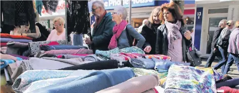  ?? RP-FOTO: FRANZ-HEINRICH BUSCH ?? Gemustert oder einfarbig, fest oder leicht: Bei der großen Auswahl an den Ständen in der Fußgängerz­one schauten viele Besucher genau hin.