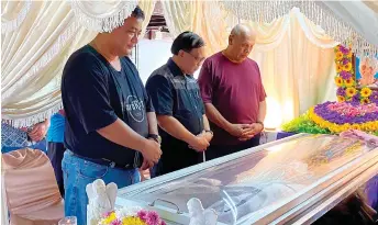  ?? ?? (From left) Martin and Jamit pay last respects to Stephen’s late mother during the wake at the family’s residence in Sri Aman.