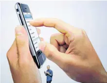  ?? [AP FILE PHOTO] ?? Apple CEO Tim Cook speaks Sept. 9, 2014 in front of a screen with an iPhone during an announceme­nt of new products in Cupertino, Calif.