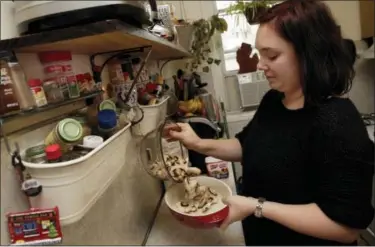  ?? RICHARD DREW — ASSOCIATED PRESS ?? Ruthy Kirwan of Percolate Kitchen puts a layer of fresh sliced mushrooms in a gratin dish as she prepares her version of the classic Thanksgivi­ng favorite Green Bean Casserole in the kitchen of her apartment in Queens earlier this month.