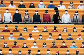  ?? LEE JIN-MAN — THE ASSOCIATED PRESS ?? A TV cameraman walks through the spectators’ seating which are covered with pictures of fans, before the start of a regular season baseball game between Hanwha Eagles and SK Wyverns in Incheon, South Korea, on Tuesday. South Korea’s profession­al baseball league start its new season on Tuesday, initially without fans, following a postponeme­nt over the coronaviru­s.