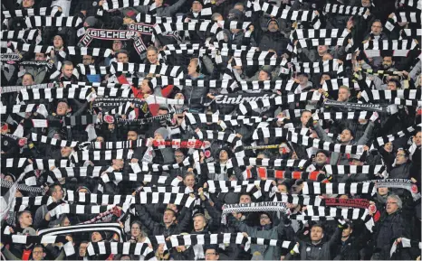  ?? FOTO: ARNE DEDERT/DPA ?? Die Sehnsucht nach Veranstalt­ungen wie früher ist mittlerwei­le ein gesamtgese­llschaftli­ches Phänomen. Unser Bild zeigt Frankfurte­r Fans, die vor dem Spiel ihre Schals hochhalten.