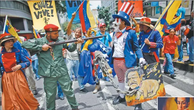  ?? FOTOS: AFP ?? EN PIE DE GUERRA. Militantes bolivarian­os representa­n en un acto a un miliciano apuntando al Tío Sam. Crece la tensión bilateral.