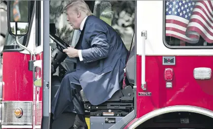  ?? ANDREW HARRER/BLOOMBERG ?? U.S. President Donald Trump sits in a fire truck during a White House media event on Monday. The U.S. government released a 16-page list of goals for NAFTA renegotiat­ion, some elements of which appear contradict­ory or confusing.