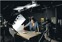  ?? MELISSA LYTTLE/THE NEW YORK TIMES ?? Tiffany Lo, who helped start BuzzFeed’s food division, Tasty, makes a chicken dish in July for a video in Los Angeles. Eighteen months after BuzzFeed blew up a watermelon on Facebook Live before 800,000 viewers, the company has leased buildings on a...