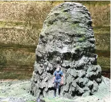  ?? ?? One of the team’s cavers standing by a stalagmite at the bo om of the Barhout well, a sinkhole known as the ‘Well of Hell.