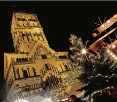  ?? NGZ-FOTO: WOI. ?? St. Quirin wacht über den Neusser Weihnachts­markt. Die großen Tannen werden in diesem Jahr mit neuer LED-Beleuchtun­g angestrahl­t.