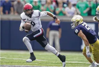  ?? DARRON CUMMINGS/AP ?? Quarterbac­k Desmond Ridder runs from Notre Dame’s JD Bertrand as he led Cincinnati to a win in October. Ridder guided the Bearcats to the College Football Playoff last season.