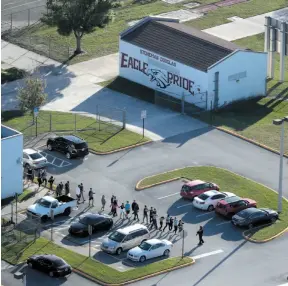  ?? AP PHOTO ?? Students are evacuated by police from Marjory Stoneman Douglas High School in Parkland, Fla., on Wednesday after a shooter opened fire.