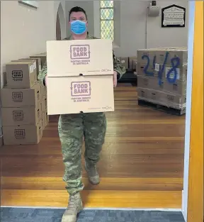  ??  ?? Boot on the ground: An ADF member delivering food parcels to families in quarantine.