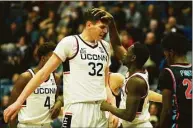  ?? Tyler Sizemore / Hearst Connecticu­t Media ?? UConn’s Donovan Clingan (32) and Hassan Diarra (5) celebrate after a made basket on Sunday.