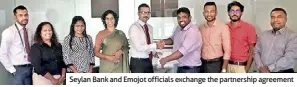  ?? ?? Seylan Bank and Emojot officials exchange the partnershi­p agreement