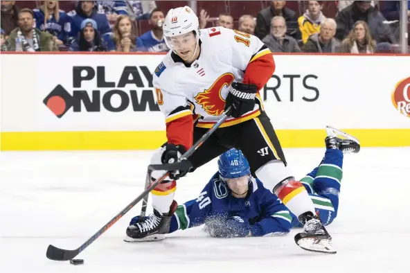  ?? RICH LAM/GETTY IMAGES ?? Calgary’s Derek Ryan gets past Vancouver’s Elias Pettersson on Saturday at Rogers Arena in Vancouver. The Flames take on league-best Tampa Bay on Tuesday.