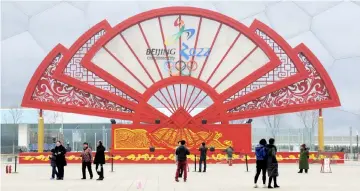  ??  ?? People walk past a installati­on in the shape of a fan bearing the bidding logo of Beijing 2022 Winter Olympics, in front of the National Aquatics Centre, also known as the Water Cube, in Beijing, China in Feb 15, 2015 file photo. — Reuters photo