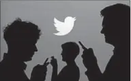  ??  ?? People holding mobile phones are silhouette­d against a backdrop projected with the Twitter logo in this illustrati­on picture taken September 27, 2013. (Reuters.com)