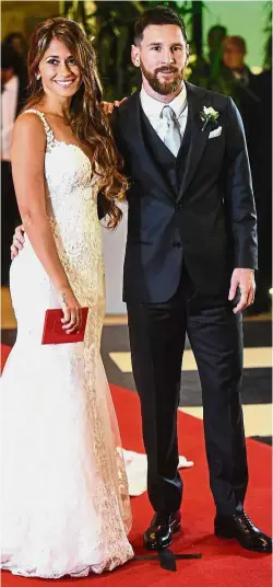  ??  ?? Happy couple: Argentina star Lionel Messi and bride Antonella Roccuzzo posing for photograph­ers just after their wedding at the City Centre Complex in Rosario, Argentina, on Friday. — AFP