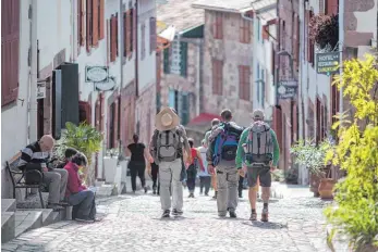  ?? FOTO: FLORIAN SCHUH ?? Wie im französisc­hen Saint-Jean-Pied-de-Port ist das entlang des Jakobswegs vielerorts ein bekannter Anblick: Pilger ziehen zu Fuß durch die Städte.