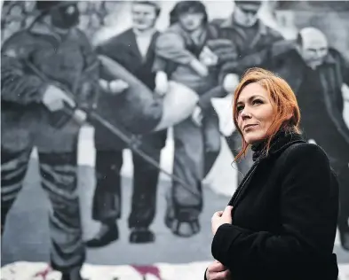  ?? CHARLES MCQUILLAN / GETTY IMAGES ?? Julieann Camphill stands beside the Bloody Sunday mural depicting the body of her uncle Jackie Duddy being carried away after his shooting in the Rossville Street area where soldiers opened fire on civil rights marchers.
