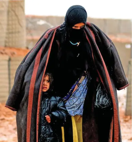  ?? (AFP) ?? A refugee and a child at the camp which is a cluster of makeshift tents and mud huts.