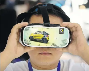  ?? MARK SCHIEFELBE­IN/ THE ASSOCIATED PRESS ?? A young visitor watches a virtual reality presentati­on by automaker Smart Automobile at the Beijing Auto Show. Virtual reality could transform the consumer experience.