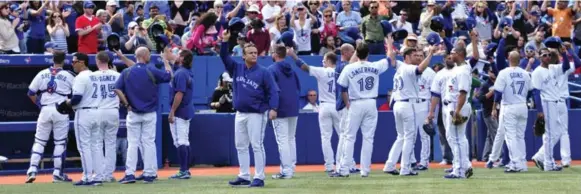  ?? CARLOS OSORIO/TORONTO STAR ?? Blue Jay players salute the 44,551 fans at the Rogers Centre after Sunday’s 7-6 loss to the Rays in the final game of the regular season. The team finished just one win better than last year.