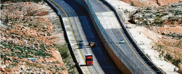  ?? Foto: Thomas Coex, Getty ?? Links fahren die Palästinen­ser, die rechte Seite ist für israelisch­e Siedler reserviert. Das Bild von einer neuen Landstraße nahe Jerusalem steht symbolisch für den Konflikt im Westjordan­land.