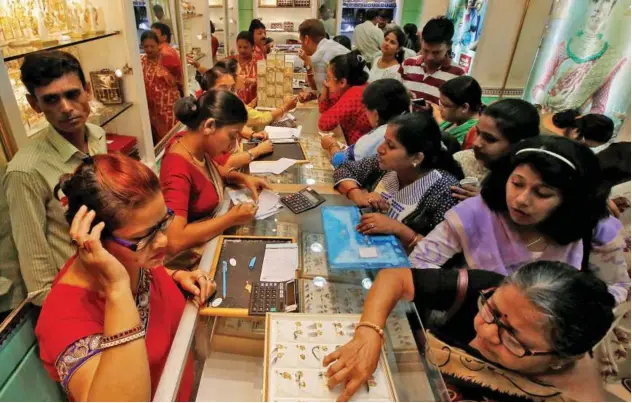  ??  ?? People buy gold ornaments at a jewellery shop in Kolkata.