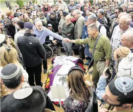  ?? ARIEL SCHALIT AP ?? Mourners gather around the grave of American-Israeli Amichai Yisrael Yehoshua Oster during his funeral in the West Bank settlement of Karnei Shomron on Tuesday. Oster, 24, was a soldier who was killed during the Israeli military’s ground operation in the Gaza Strip.