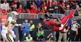  ?? David Goldman / AP ?? Atlanta Falcons middle linebacker Deion Jones (right) intercepts a ball in the end zone ahead of New Orleans Saints tight end Josh Hill during the second half in Atlanta.