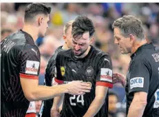  ?? FOTO: IMAGO IMAGES ?? Handball-Nationalsp­ieler Patrick Groetzki (Mitte) verzieht das Gesicht, Bundestrai­ner Alfred Gislason fragt besorgt nach, wie es ihm geht.