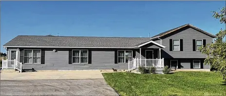  ?? CONTRIBUTE­D PHOTOS ?? The three-bedroom tri-level with about 2,060 sq. ft. of living space features a covered porch and an oversized concrete driveway extension that leads to the rear outbuildin­g/garage.