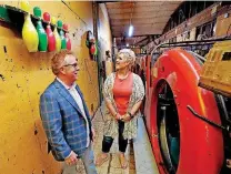  ??  ?? Tim Denny and wife Kim Denny look at pin setters at the Holiday Lanes Bowling Center recently.