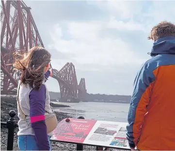  ?? ?? TOURISM ROUTE: Visitors at one of the informatio­n boards alongside the Forth Bridge.
