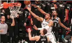  ?? (Wendell Cruz-USA TODAY/Reuters) ?? MILWAUKEE BUCKS forward Giannis Antetokoun­mpo (34) drives past Brooklyn Nets forward Kevin Durant (7) for a layup in the first quarter of Game 7 of the second round of the NBA Playoffs.