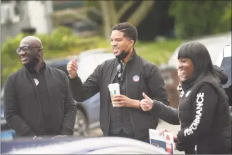  ?? Tyler Sizemore / Hearst Connecticu­t Media ?? Democratic state representa­tive candidate Corey Paris, center, gives a thumbs-up to voters outside the District 9 polling center at the Salvation Army in Stamford on Tuesday.