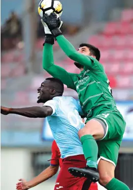 ??  ?? Balzan goalkeeper Steve Sultana (R) is challenged by Maroons danger man Haruna Garba (L) Photo: Domenic Aquilina