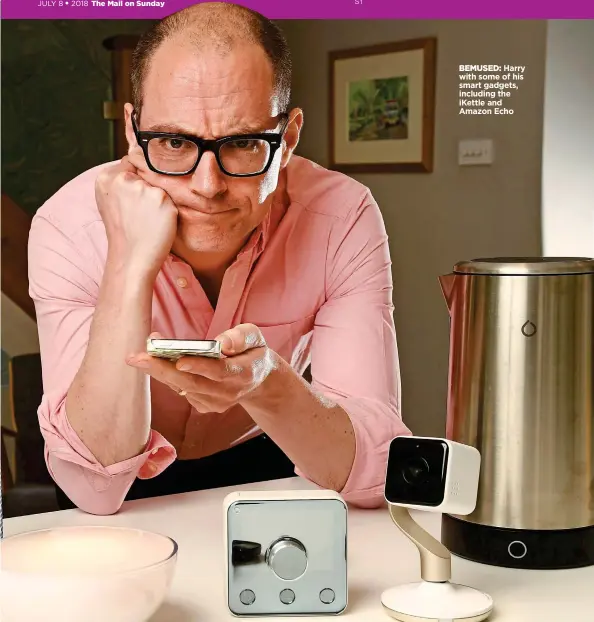  ??  ?? BEMUSED: Harry with some of his smart gadgets, including the iKettle and Amazon Echo