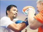  ?? Chris Hyde Getty Images ?? MANNY PACQUIAO works with trainer Freddie Roach ahead of fight Saturday in Brisbane, Australia.