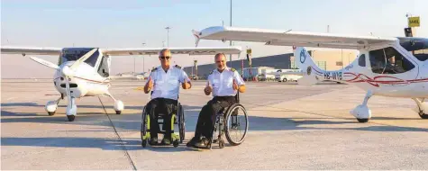  ??  ?? Pilots Mike Lomberg (left) and Guillaume Feral celebrate their arrival from Saudi Arabia, at Dubai World Central on Tuesday.