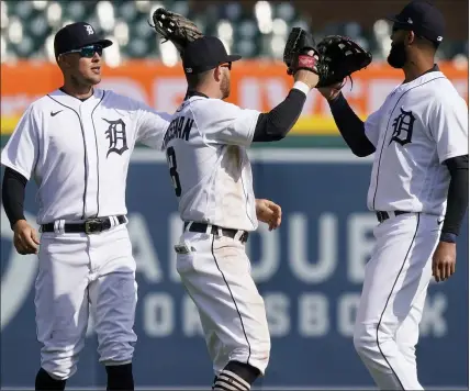  ?? CARLOS OSORIO PHOTOS — THE ASSOCIATED PRESS ?? Detroit Tigers’ outfielder­s Jacoby Jones, left, Robbie Grossman, center, and Niko Goodrum celebrate Saturday’s win over Cleveland.