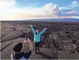  ?? ?? Kelly Ann Kobayashi poses for Chad Saito, left, while standing on hardened lava rock from a previous eruption as the Mauna Loa volcano erupts Wednesday. The two were visiting from Honolulu.