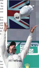  ??  ?? Mercedes’ Lewis Hamilton celebrates winning the Hungarian Grand Prix on the podium with trophy. — Reuters