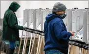  ?? KYLE GRILLOT/ THE NEWYORK TIMES ?? Avoter casts his early ballot in Dayton onMarch 16. Voters can vote bymail and start voting early at their boards of elections onOct. 6.