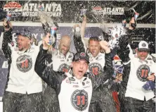  ?? Jerry Markland / Getty Images ?? Kevin Harvick celebrates with his crew in Victory Lane after winning the NASCAR Monster Energy Cup race.