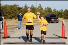  ??  ?? Father Dan and son Nikolas Toocheck finish their first marathon in Delaware to kick off the “Running the World for Children” cause.