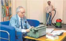  ?? FOTO: WOLFGANG MARIA WEBER/IMAGO ?? Johannes Mario Simmel bei der Arbeit an der Schreibmas­chine: Im Hintergrun­d rückt schon das Putzteam an.