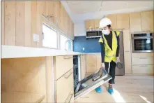  ?? STEVE MARCUS ?? Team member Andrea Hughey opens the door of a dishwasher March 30 in UNLV’S Mojave Bloom smart solar home in Henderson. The house, designed and completed by students, is UNLV’S entry in the Department of Energy’s 2020 Solar Decathlon build challenge.