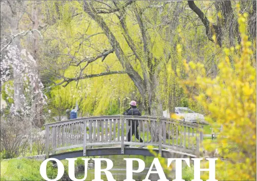  ??  ?? A woman walks across a bridge on a path through Binney Park in Old Greenwich on Sunday, April 26.