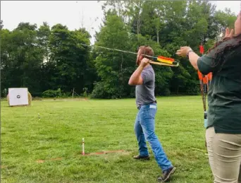  ?? Sean Hamill/Post-Gazette ?? With Meadowcrof­t Rockshelte­r tour guide Maria Vilotti’s guidance, Sam Carroll, 25, of Washington, Pa., tries to throw the ancient weapon, the atlatl, for the first time Saturday.